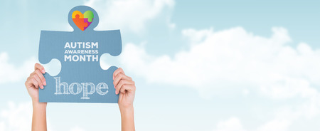 Hands showing jigsaw puzzle against blue skyの写真素材