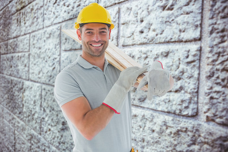 Happy carpenter against grey brick wallの写真素材