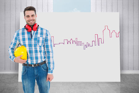 Confident manual worker with hardhat and ear muffs against composite image of white card