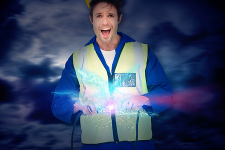 Electrician getting a shock while holding wires against blue sky with white cloudsの写真素材
