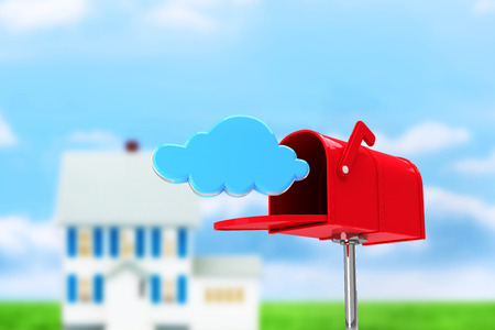 Red email postbox against house in the distanceの写真素材