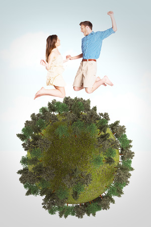Cheerful young couple jumping against blue skyの写真素材