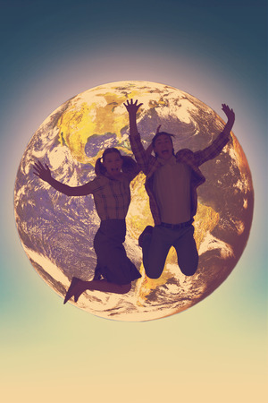 Geeky hipsters jumping and smiling against blue skyの写真素材