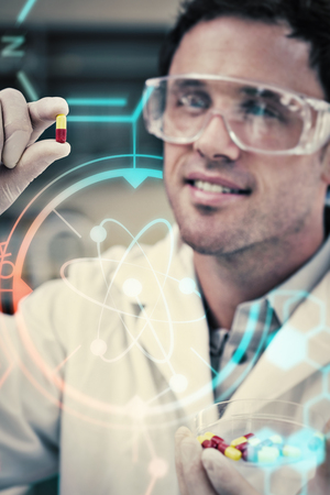 Science and medical graphic against male scientist analyzing pills in the laboratory