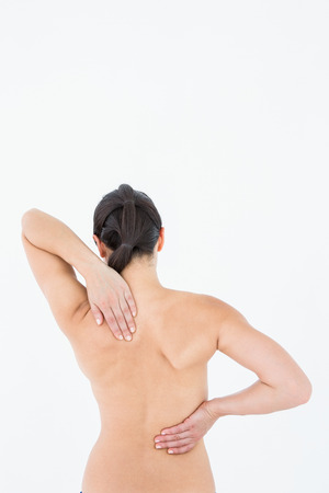 Brunette touching her painful neck on white backgroundの写真素材