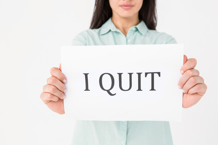 Brunette holding i quit card on white background