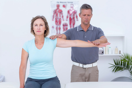 Doctor examining his patient arm in medical office