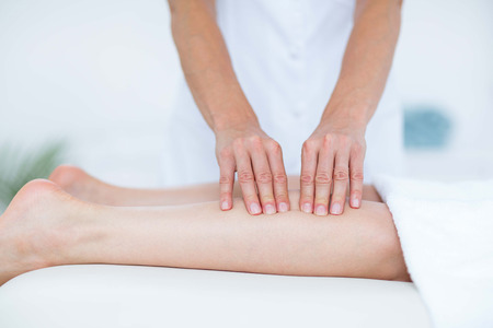 Physiotherapist doing leg massage in medical officeの写真素材