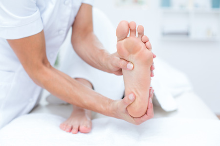 Physiotherapist doing foot massage in medical officeの写真素材