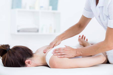 Physiotherapist doing neck massage in medical officeの写真素材