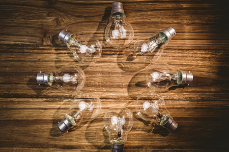 Light bulbs forming frame on wooden tableの写真素材