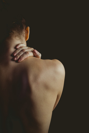 woman with a neck injury on black backgroundの写真素材