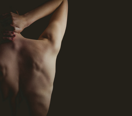 woman with a neck injury on black backgroundの写真素材