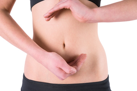 Woman with hands over belly on white backgroundの写真素材