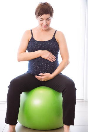 Pregnant woman keeping in shape at homeの写真素材