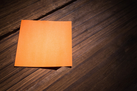 Orange post it on wooden backgroundの写真素材
