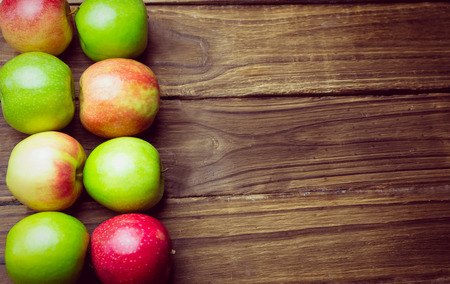 Fresh colorful apples on wooden backgroundの写真素材