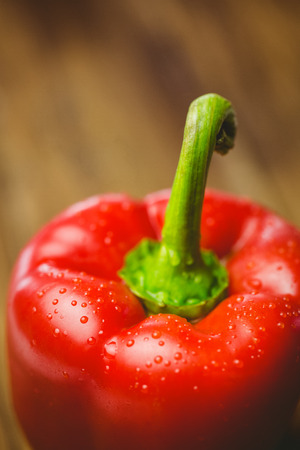 Red pepper with water drops on wooden backgroundの写真素材