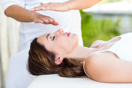 Calm woman receiving reiki treatment in the health spaの写真素材
