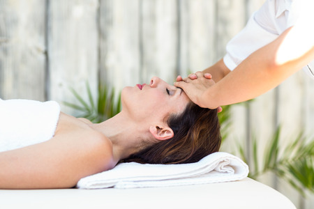 Brunette receiving forehead massage at the spaの写真素材