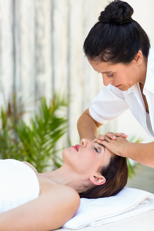 Brunette receiving forehead massage at the spaの写真素材