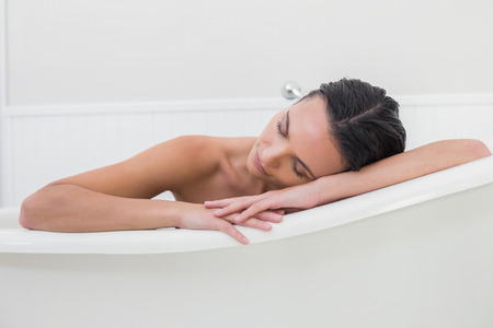 Pretty brunette taking a bath in a bathroom
