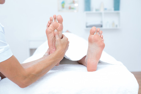 Physiotherapist doing foot massage in medical officeの写真素材