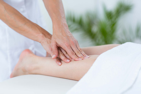 Physiotherapist doing leg massage in medical officeの写真素材