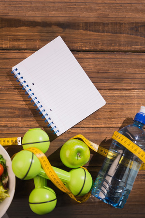 Notepad with indicators of healthy lifestyle on wooden tableの写真素材