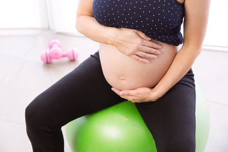 Pregnant woman keeping in shape at homeの写真素材