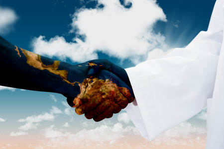 Closeup of a doctor and patient shaking hands against blue skyの写真素材