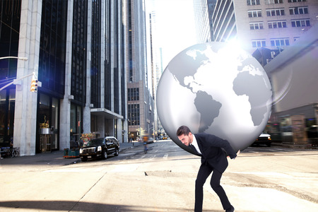 Businessman carrying the world against new york streetの写真素材