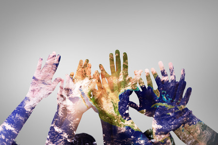 People raising hands in the air against grey vignetteの写真素材