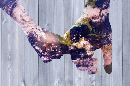 Loving young couple holding hands against wooden planksの写真素材