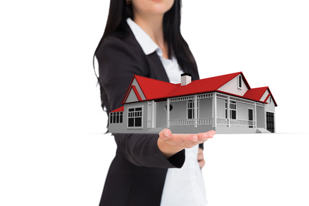 Pretty businesswoman presenting with hand against 3d houseの写真素材
