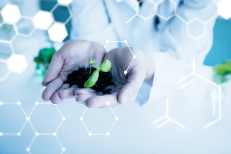 Science graphic against woman holding soil and plants