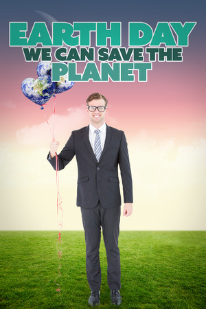 Happy geeky hipster businessman holding balloons against magical skyの写真素材