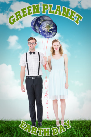 Geeky hipster couple hands in hands looking at camera  against blue skyの写真素材