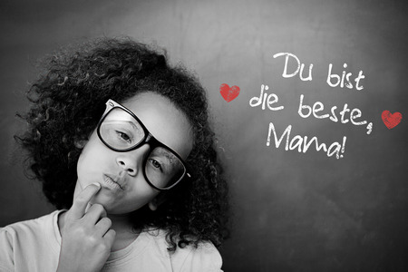 Schoolchild with blackboard against german mothers day messageの写真素材