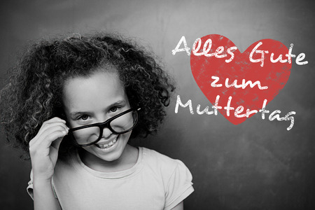 Schoolchild with blackboard against german mothers day messageの写真素材