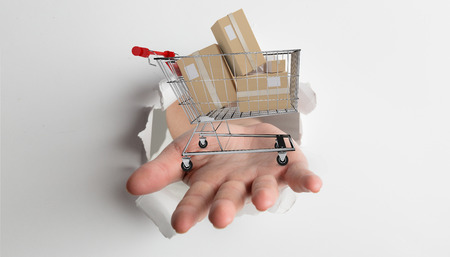 Hand bursting through paper against white background with vignetteの写真素材