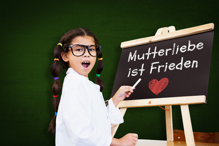 Cute pupil with chalkboard against greenの写真素材