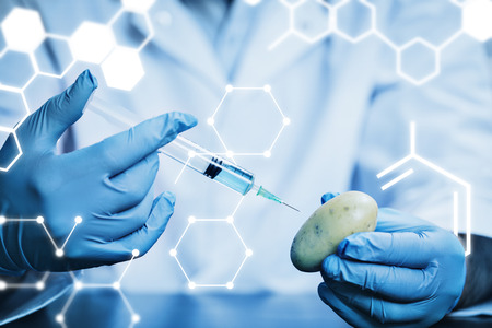 Science graphic against food scientist injecting a potatoの写真素材