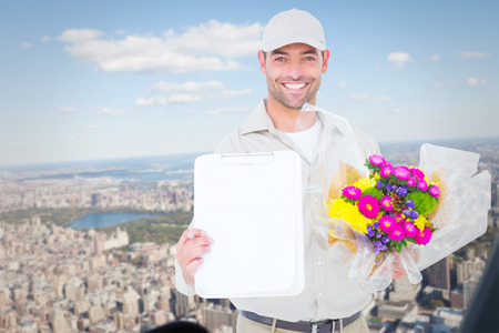 Flower delivery man showing clipboard against new yorkの写真素材