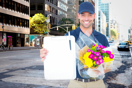 Flower delivery man showing clipboard against new york streetの写真素材