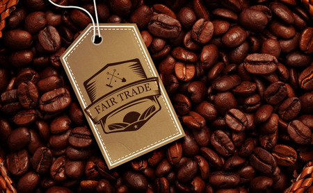 Fair Trade graphic against close up of a basket full of dark coffee beansの写真素材