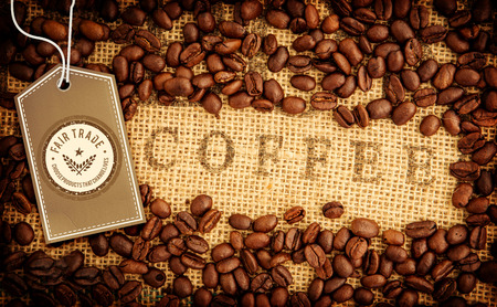 Fair Trade graphic against coffee beans surrounding coffee stamp on sackの写真素材