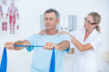 Doctor examining her patient back in medical officeの写真素材