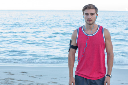 Handsome runner looking at camera at the beachの写真素材
