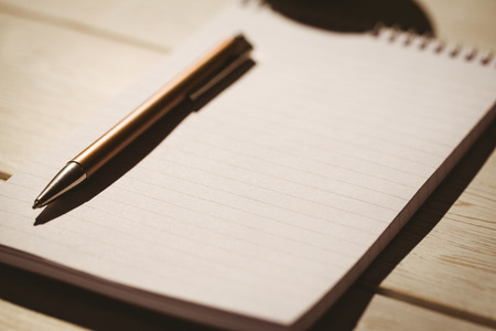 Empty notepad with pen on a deskの写真素材